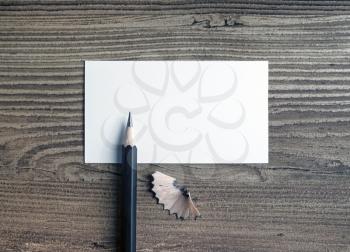 Photo of blank business card and pencil on wooden background. Responsive design template with plenty of copy space. Top view.