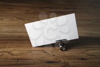 Photo of blank business card on wood table background. Mockup for ID. Blank template for branding identity.