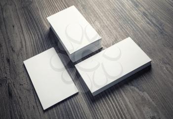 Three piles of blank business cards on wood table background. Mock-up for branding identity for designers. Blank template for your design.