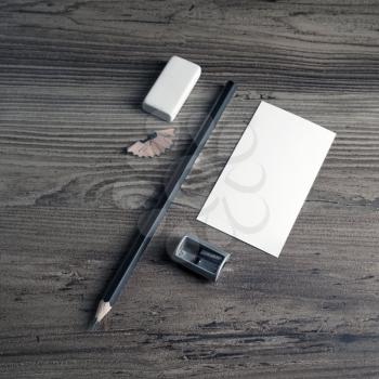 Photo of blank business card, pencil, eraser and sharpener on wooden table background. Bank stationery elements. Responsive design mockup. Top view.
