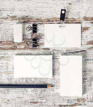 Photo of blank stationery set. business cards, badge, pencil and eraser on vintage wood background. Template for placing your design. Top view.