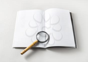 Blank opened book and magnifier on paper background. Template for placing your design. Responsive design mockup.