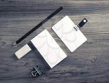 Blank corporate identity template on wood background. Bank business card, badge, pencil and eraser. Top view.