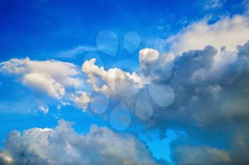 Picturesque cumulus clouds against the background of a bright blue sky.