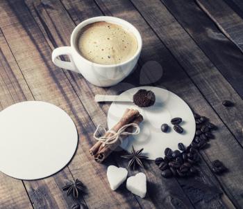 Coffee cup and spices on wooden background.