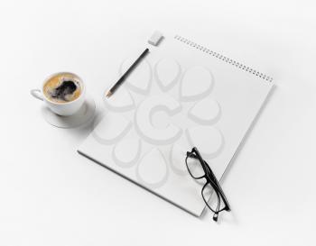 Blank stationery mockup. Notebook, glasses, coffee cup, pencil and eraser on white paper background. Template for placing your design.