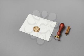 Paper envelope, wax seal and stamp on gray paper background. Mockup for placing your design.