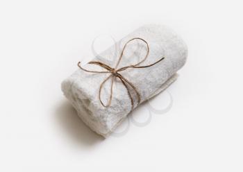 White towel tied with rope on paper background. For spa treatments or in a hotel.