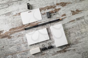 Blank business cards, badge, pencil and eraser on vintage wooden background. Flat lay.