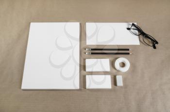 Photo of blank stationery set on craft paper background. Responsive design template. Top view.