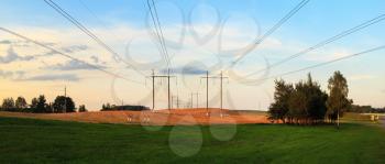 Panoramic shot of field after harvest in the countryside. Pillars with high-voltage electric wires. Panorama shot.