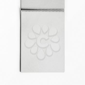 Open sketchbook with blank pages on white paper background. Album with spiral. Top view. Flat lay.