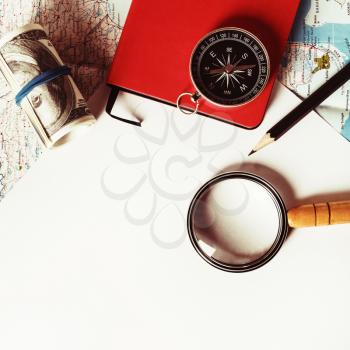 Travel stationery set. Paper, magnifier, map, compass, notebook, money and pencil. Tourism concept. Vintage toned image. Top view. Flat lay.