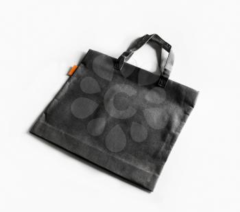 Blank black canvas shopping bag on white paper background.