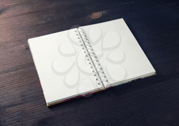 Photo of blank notebook on wood table background. Template for design presentations and portfolios.