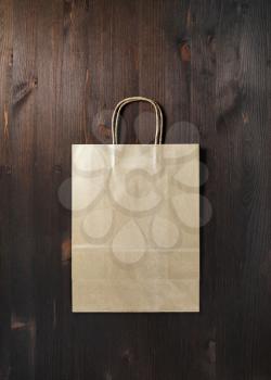Blank brown paper bag on wooden background. Flat lay.
