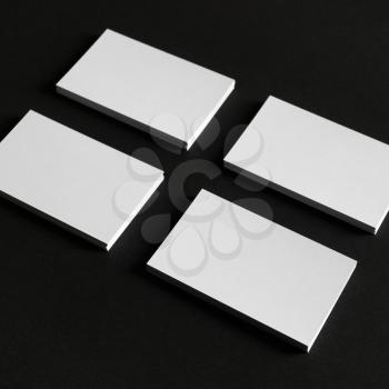 Photo of blank business cards on black paper background. Template for branding identity.