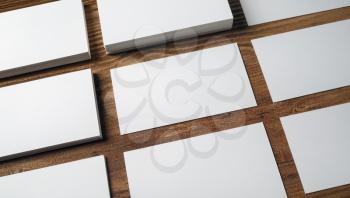 Many blank business cards on wood table background. Blank paperwork template for placing your design. Mockup for ID.