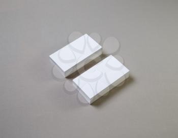 Photo of blank white business cards on gray paper background.