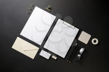 Photo of blank stationery set on black paper background. Template for branding identity. Objects for placing your design. Flat lay.