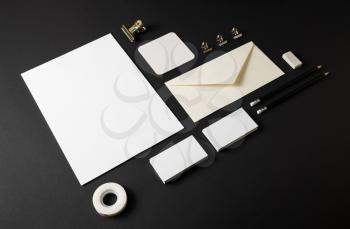 Photo of blank stationery set on black paper background. Corporate identity template. Responsive design mockup.