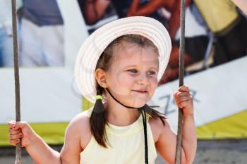 Happy smiling little girl in white hat. Selective focus on child's face.
