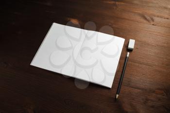 Blank stationery mock up. Brochure, pencil and eraser on wooden background. Template for placing your design.