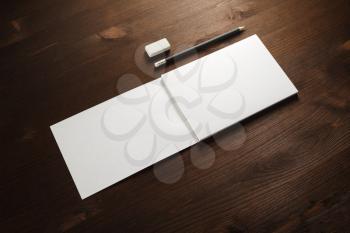 Blank notepad, pencil and eraser on wooden background. Blank stationery mockup.