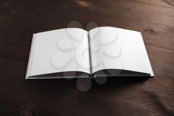 Open book or notebook with blank pages on wood table background.
