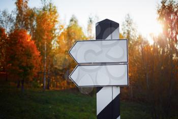 Signpost on the background of the autumn forest. Selective focus.