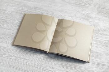 Open blank craft paper book or booklet on wooden background. Branding mock up.