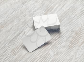 Blank white business cards on light wooden background. Mockup for branding identity.