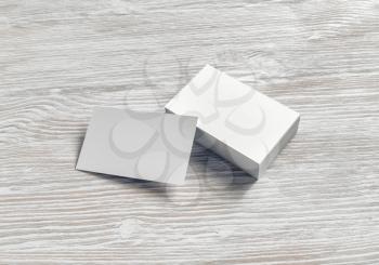 Blank white business cards on light wooden background. Mockup for branding identity.