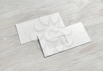 Two blank envelopes on light wooden background. Back and front. Template for branding identity.