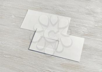 Blank paper envelopes on light wood table background. Back and front. Mockup for placing your design.