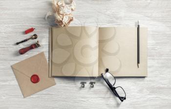 Blank sketchbook and retro stationery on light wooden background. Flat lay.