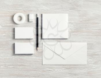 Blank corporate stationery for branding design. White ID set on light wood table background. Flat lay.