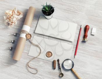 Blank envelope and vintage stationery set on light wood table background. Responsive design mockup.