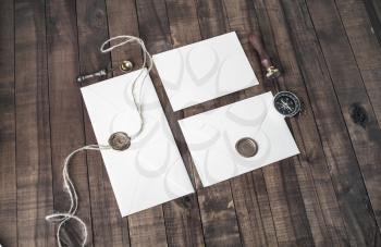 Photo of blank retro envelopes and stationery on wooden background. Mockup for your design.