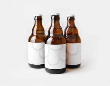 Three glass brown beer bottles with with blank labels.