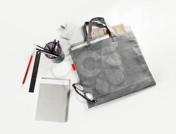 Blank gray shopping bag and stationery on paper background. Responsive design mock up.