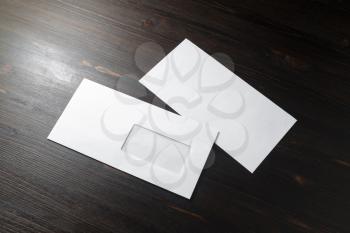 Two blank envelopes on wood table background. Front and back side. Template for branding identity.