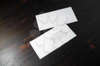 Photo of two blank paper envelopes on wooden background. Mockup for placing your design. Front and back side.