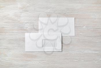 Blank paper envelopes on light wood table background. Back and front. Mockup for placing your design. Flat lay.