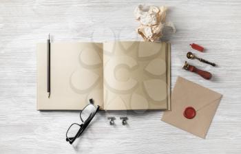 Blank book and retro stationery on light wooden background. Responsive design mockup. Flat lay.