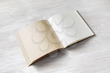 Blank book, brochure or notebook on light wooden background. Responsive design mockup.