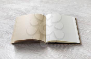 Opened blank book on light wooden background. Mockup of notebook. Flat lay.