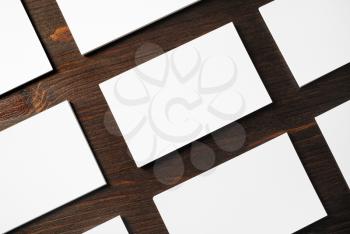 Photo of blank white business cards on wood table background. Template for branding identity.