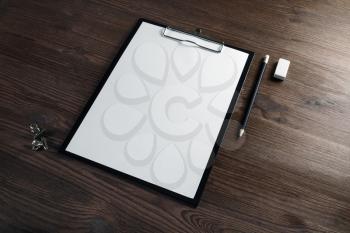 Clipboard with blank white sheet of paper, pencil and eraser on wooden background. Responsive design template.