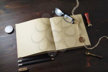 Photo of vintage blank kraft paper book and retro stationery set on wooden background.